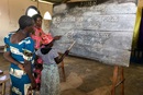 Congo women share chalkboard blessings at Epiphany. 