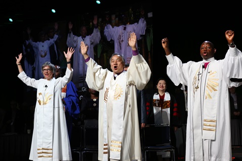 (From left) Bishops Hope Morgan Ward, Hee-Soo Jung, and John Yambasu shout, "Go" following the end of the commissioning of missionaries at the May 19 United Methodist General Conference in Portland, Ore. 