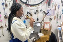 Ebiye Seimode, a student at the Boston University School of Theology and participant in the Oklahoma Indian Missionary Conference Immersion Experience, samples a flute for sale at Oklahoma Native Art & Jewelry on March 9, 2023, in Oklahoma City. Photo by Jim Patterson, UM News.