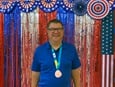James Thigpen wears his bronze medal during Wesley Glen Ministries’ Fourth of July party held after his return from the Special Olympics World Games in Berlin. Photo courtesy of Wesley Glen Ministries.