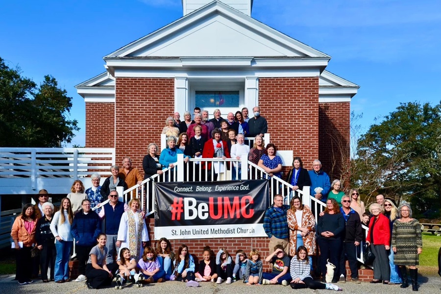 Members of St. John United Methodist Church, Avon, NC  pose in front of their #BeUMC sign. 