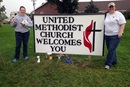 The Rev. Andrea Beyer (left) and the Rev. Cathryn Love stand near a church sign in Beaver Crossing, Nebraska. Image courtesy of Great Plains Conference/creative commons. 
