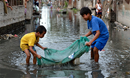 Two boys use a small net to catch fish in a flooded street in Biñan, Laguna, in the Philippines. Residents here have been subjected to increased flooding from the Laguna de Bay in recent years, and with the help of the ACT Alliance are organizing to look for alternatives. Photo: Paul Jeffrey/Life on Earth Pictures