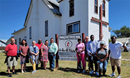 Terri Leone (2nd from left )and Drew classmates visit Rev. Calvin Hill (left of the church sign) at Browning UMC in Montana